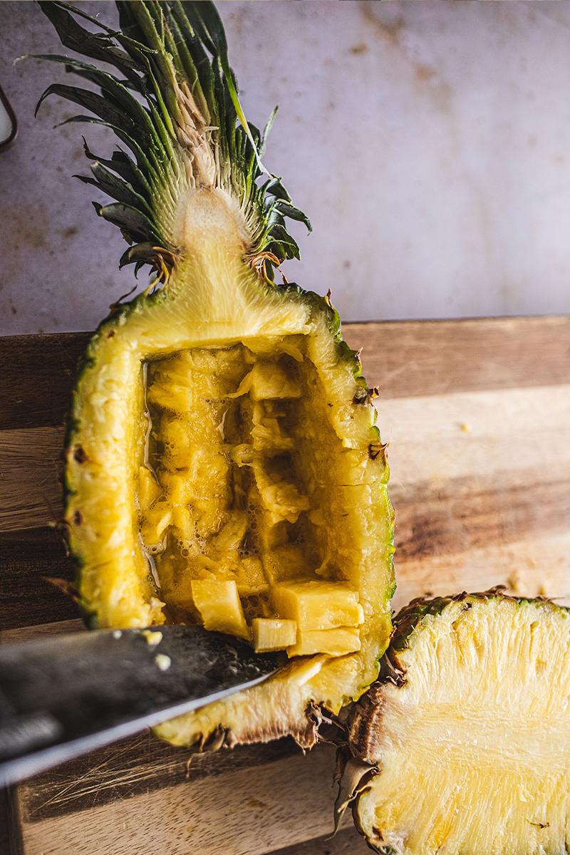Pineapple bowl on a cutting board on table.