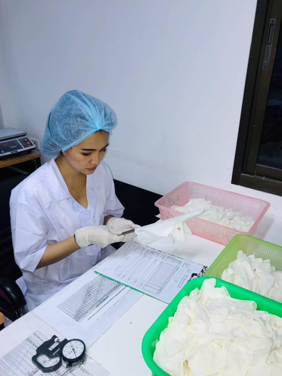 Happy Hands worker inspecting latex powdered gloves