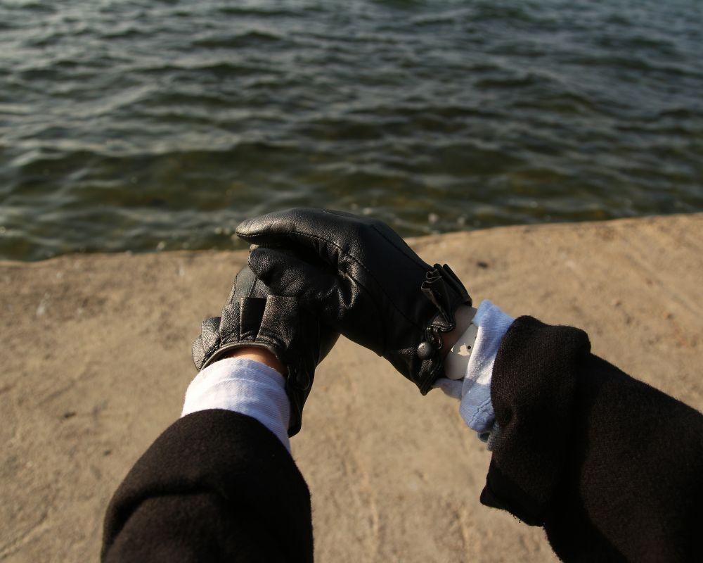 Wearing Black Leather Gloves By The Beach - How To Break In Leather Gloves - Liberty Leather Goods