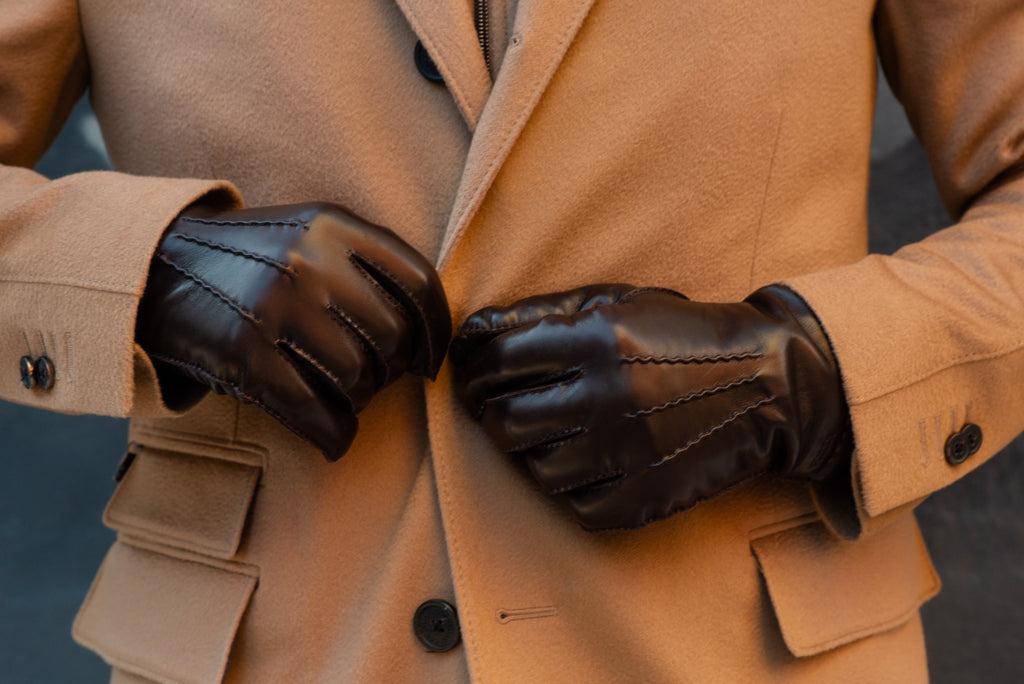 Hestra gloves worn against a Corneliani camel overcoat