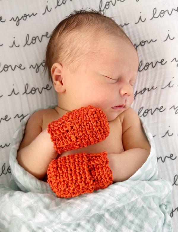 baby with crochet mittens