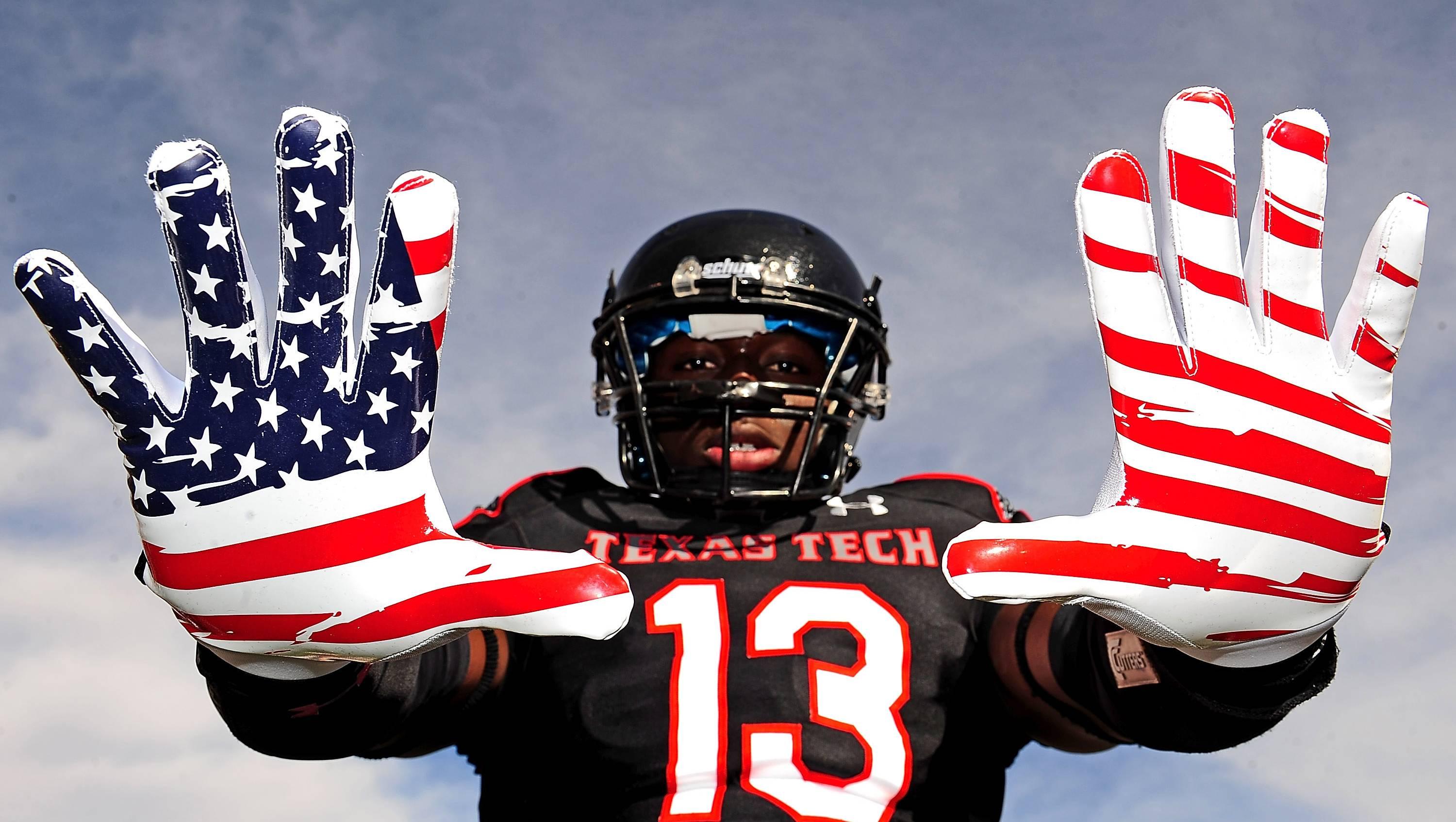 Texas Tech Red Raiders wide receiver Jakeem Grant (13) shows off his U.S. flag gloves.