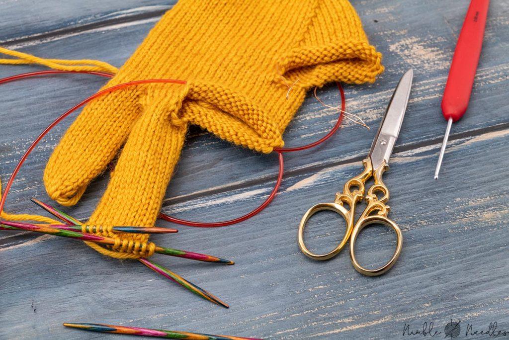 someone knitting the ring finger of gloves with double pointed knitting needles