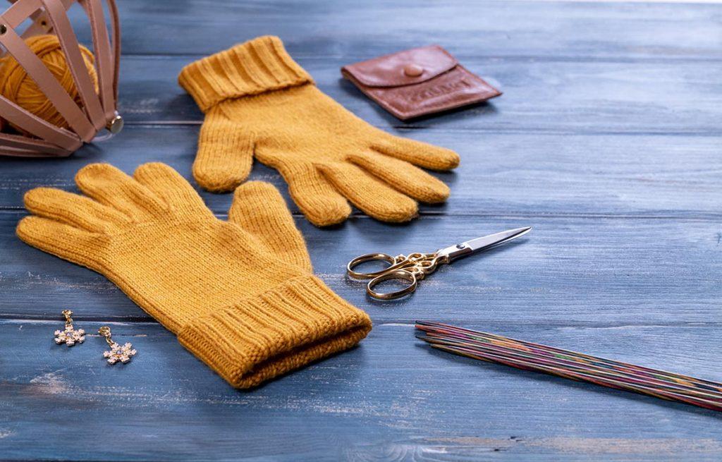 knitted glove in dk weight yarn on a wooden table