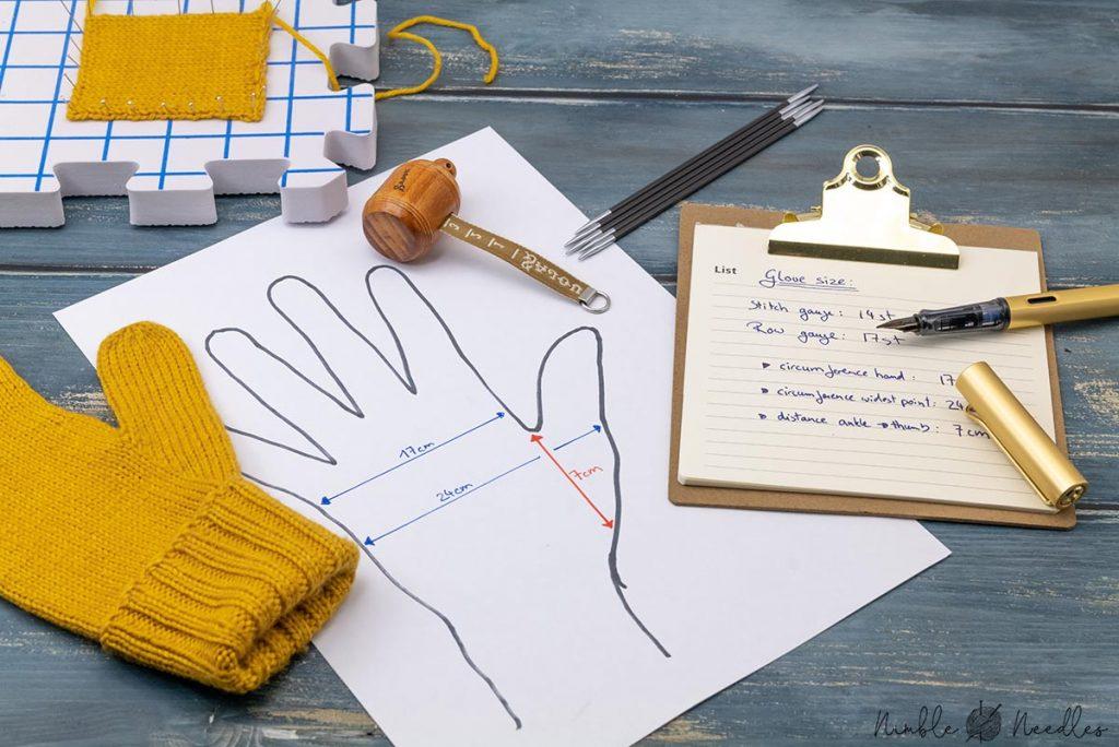 someone calculating the size of a knitted glove with a tape and a note pad