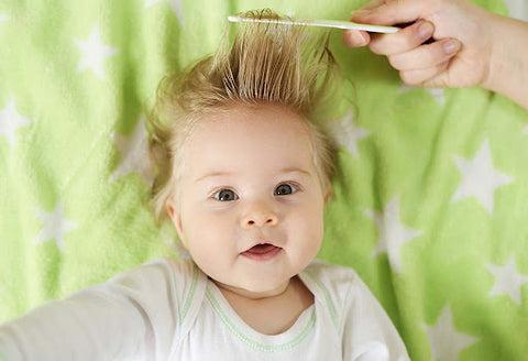 A baby getting her fringe combed