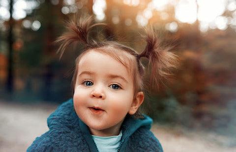 A baby with two pigtails on the top of her head