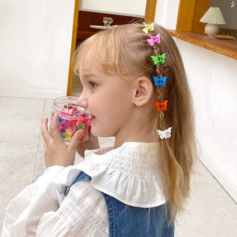 A young girl with butterfly hair clips holding her hair back from her face