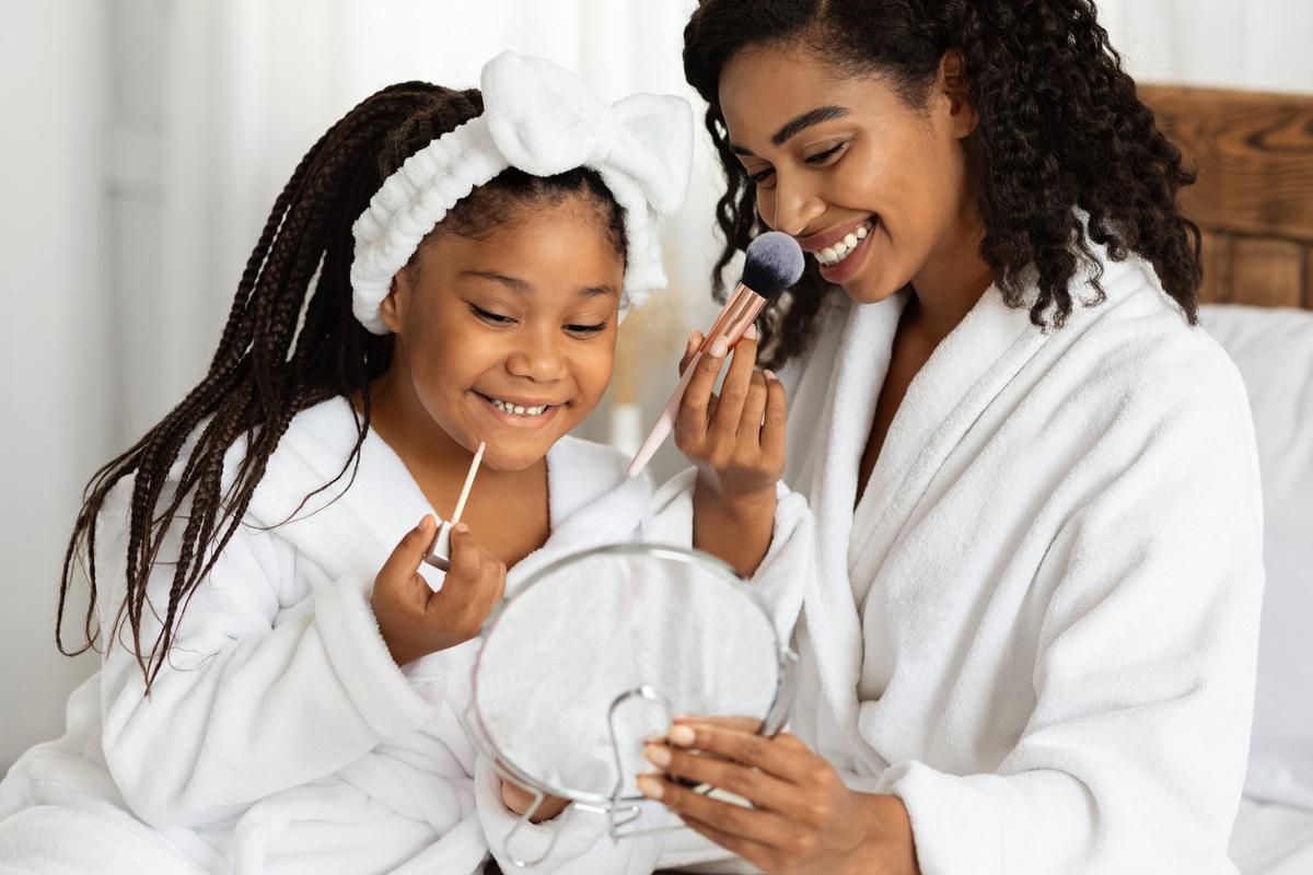 A mother and young daughter having a pampering makeup time