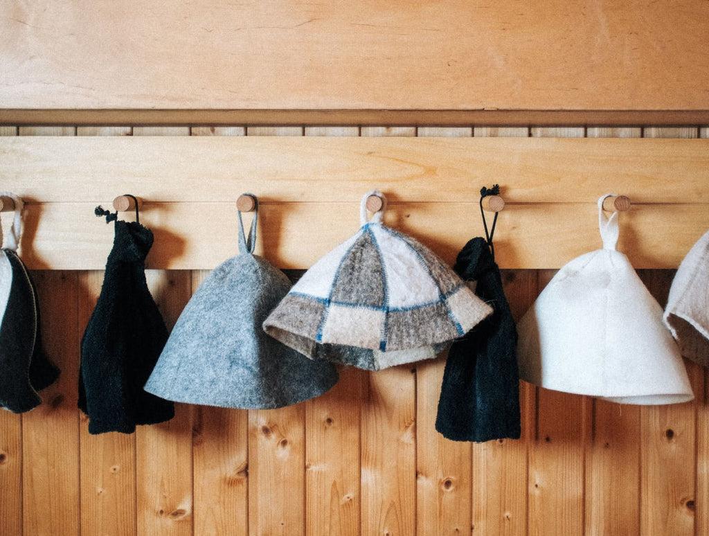 A row of sauna hats hanging on hooks