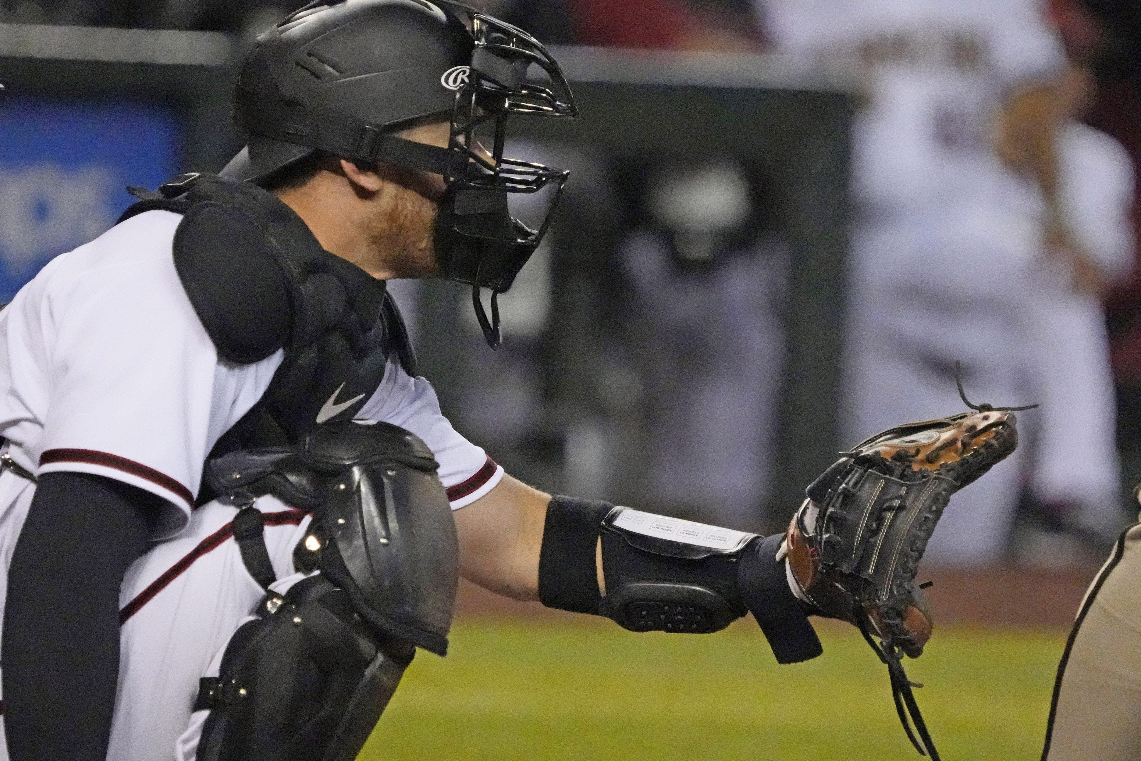 Arizona Diamondbacks catcher Carson Kelly (18) wears a PitchCom during opening day against the San Diego Padres at Chase Field in Phoenix on April 7, 2022. A PitchCom is a pitcher and catch communication device.