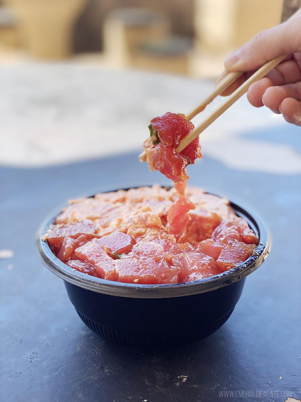 person picking up poke with chopsticks