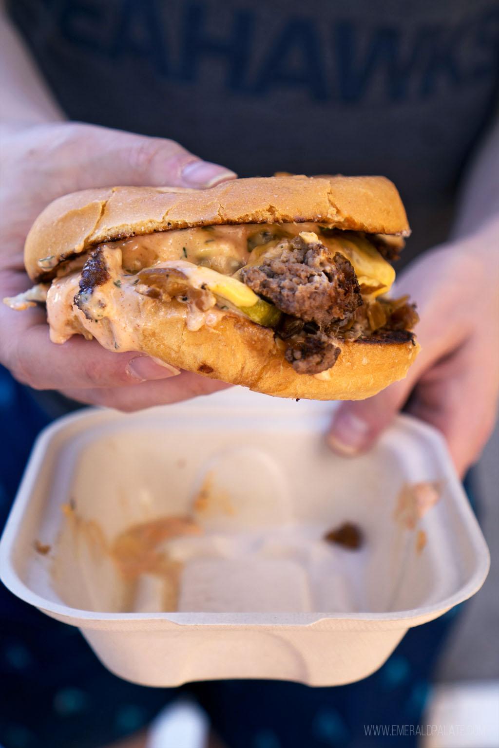 person holding cheeseburger from where Maui locals eat