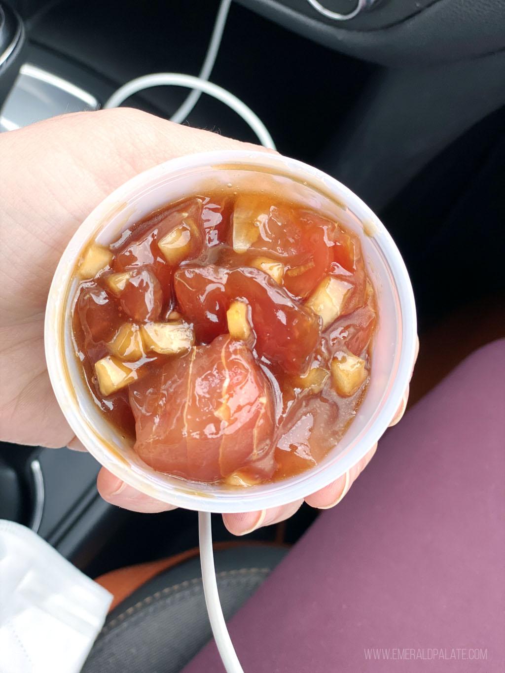 person holding sampler of poke