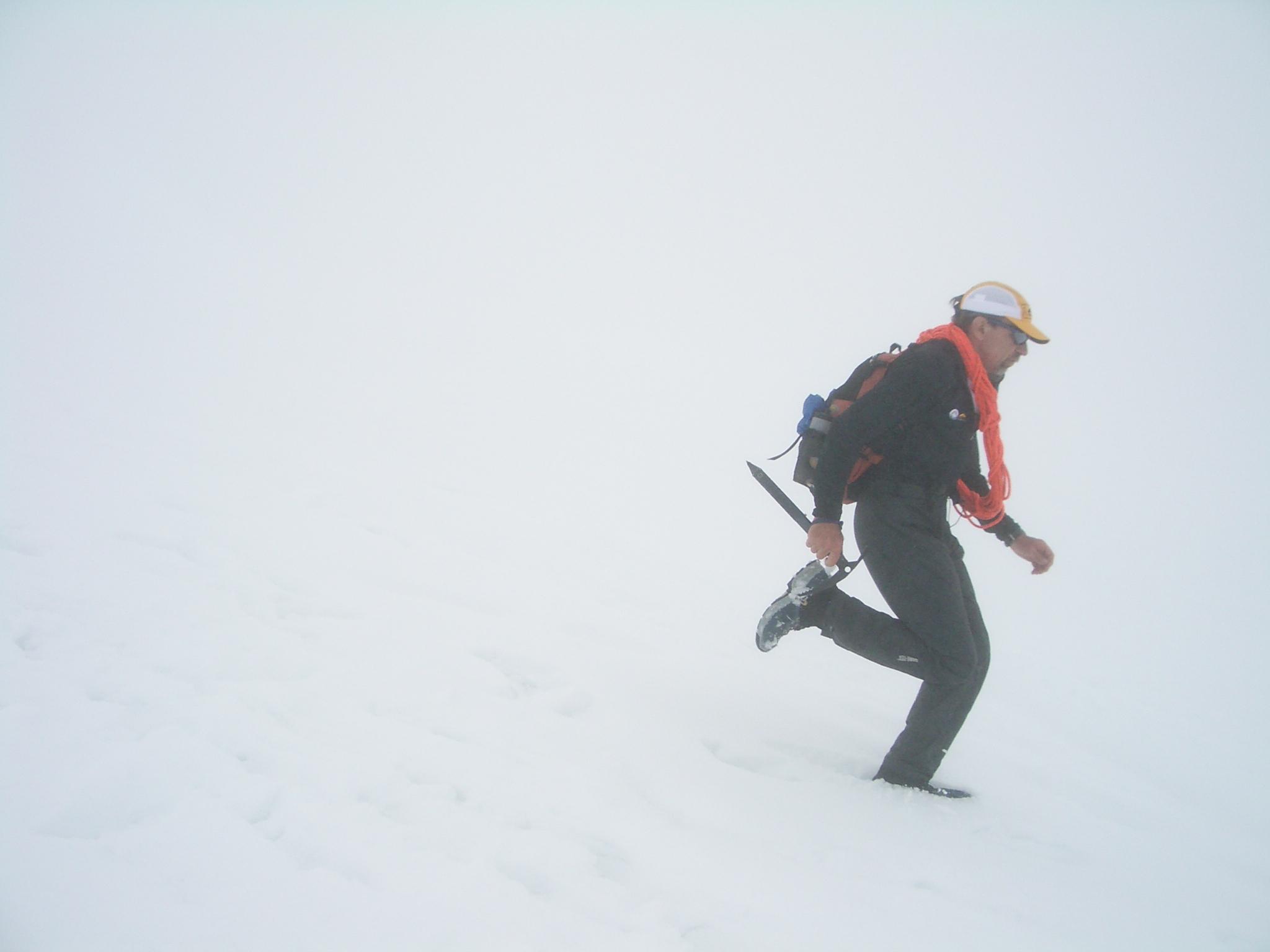 Buzz Burrell runs down a snowfield on Mt. Rainier in a white-out. He