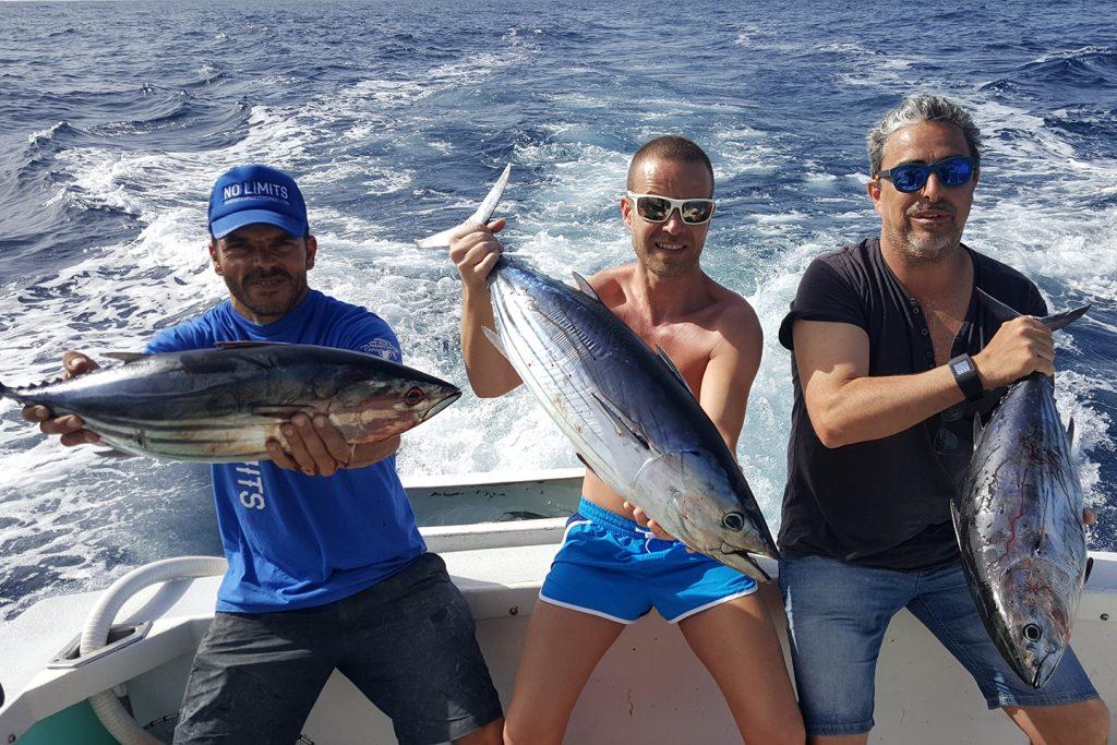 Two anglers holding a Dogtooth Tuna they caught while fishing in Port Moresby