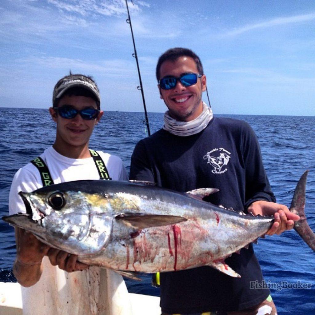 Tuna fishing: Two anglers holding an Albacore Tuna