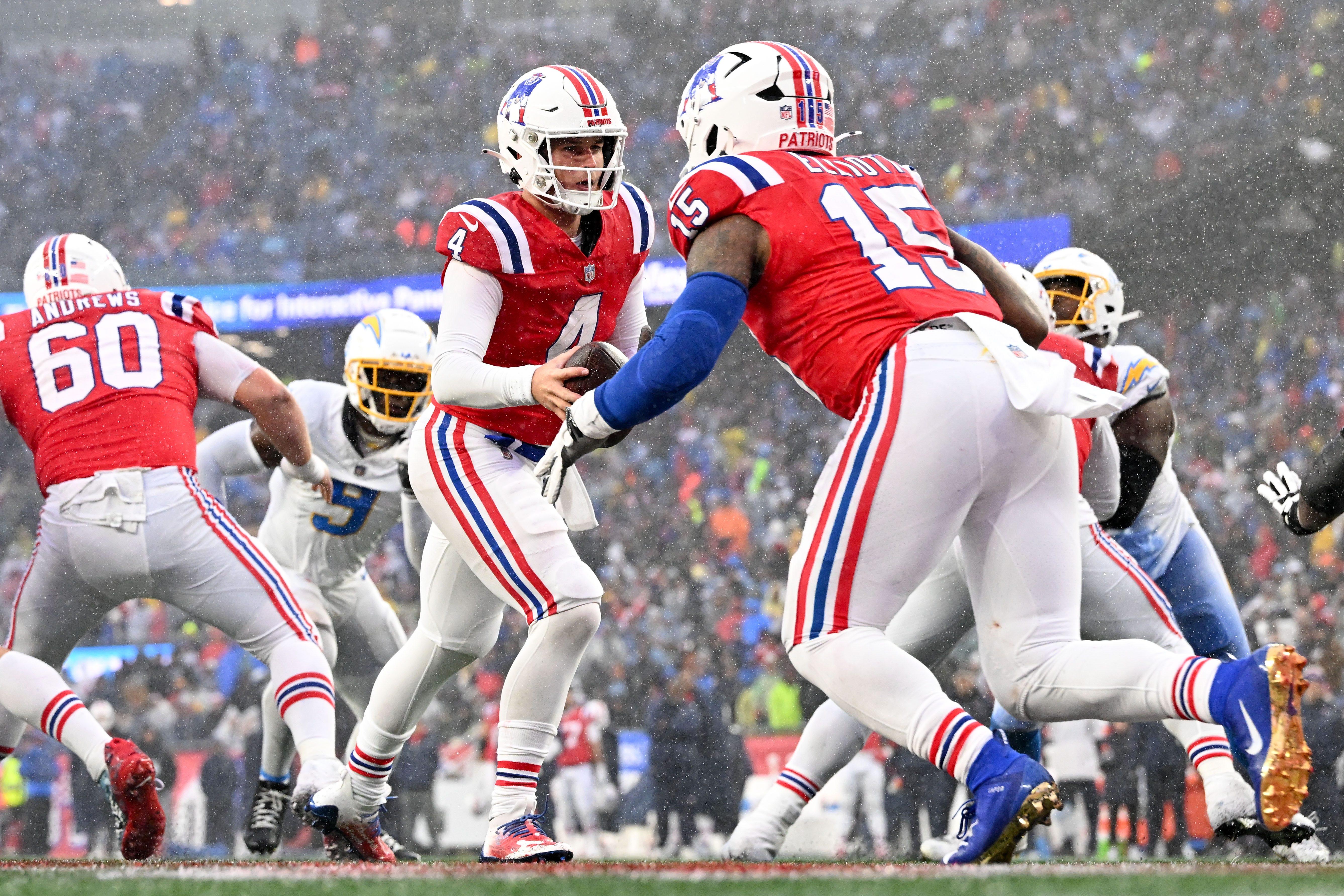 New England Patriots quarterback Bailey Zappe hands the ball off to running back Ezekiel Elliott during the second half of a game against the Los Angeles Chargers at Gillette Stadium.