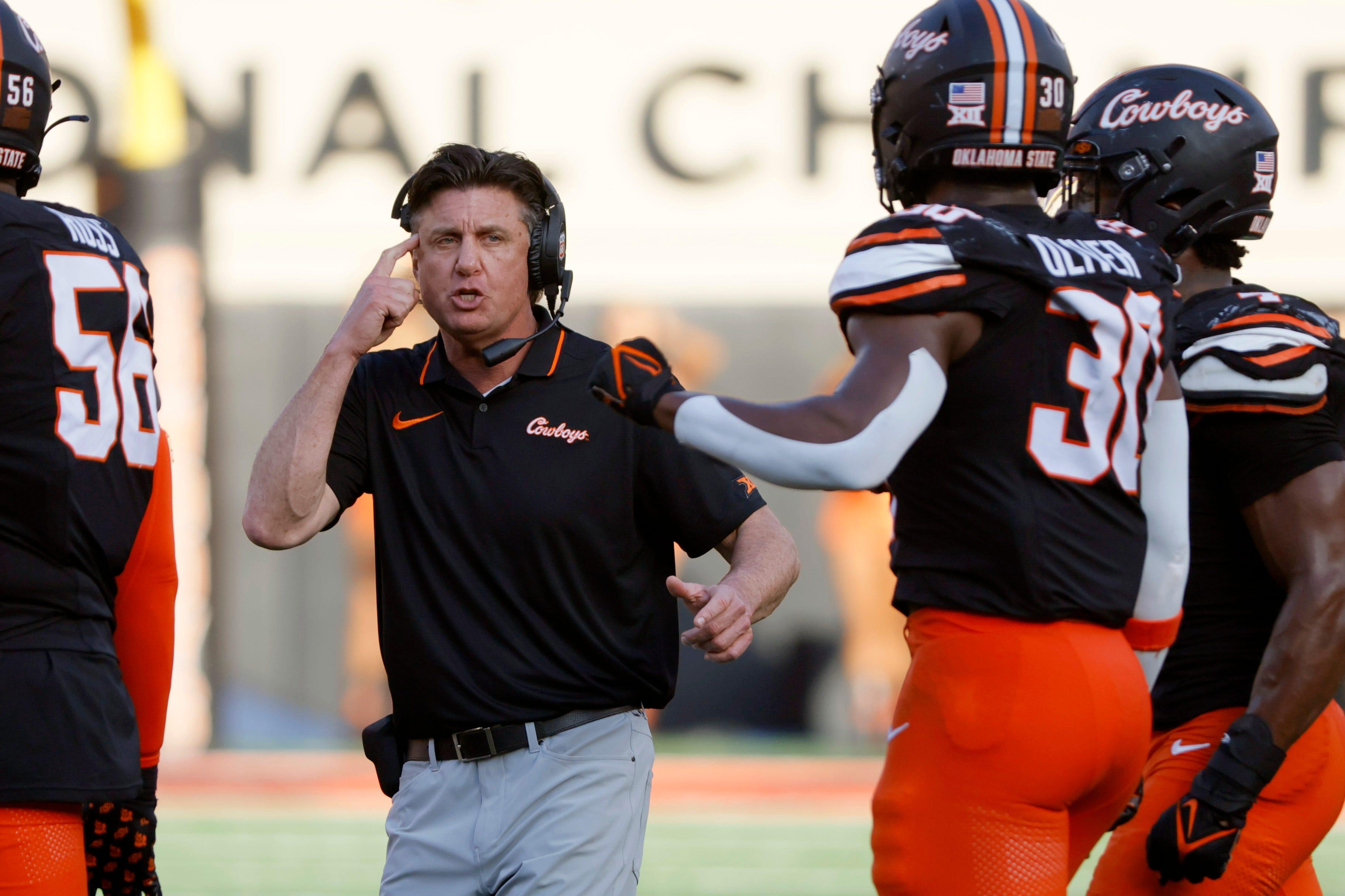 Oklahoma State coach Mike Gundy talks with his players during a Bedlam college football game between the Oklahoma State University Cowboys (OSU) and the University of Oklahoma Sooners (OU) at Boone Pickens Stadium in Stillwater, Okla., Saturday, Nov. 4, 2023. Oklahoma State won 27-24.