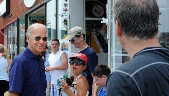 Vice President Joe Biden greets people on Rehoboth Avenue in Rehoboth Beach in 2012 while his wife, Jill, signs copies of her book at Browseabout Books. The Bidens, who are frequent visitors to Rehoboth Beach, recently bought a vacation retreat in the Cape Henlopen State Park area.