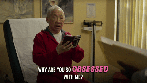 An Asian man says "Why are you so obsessed with me" while looking at his phone