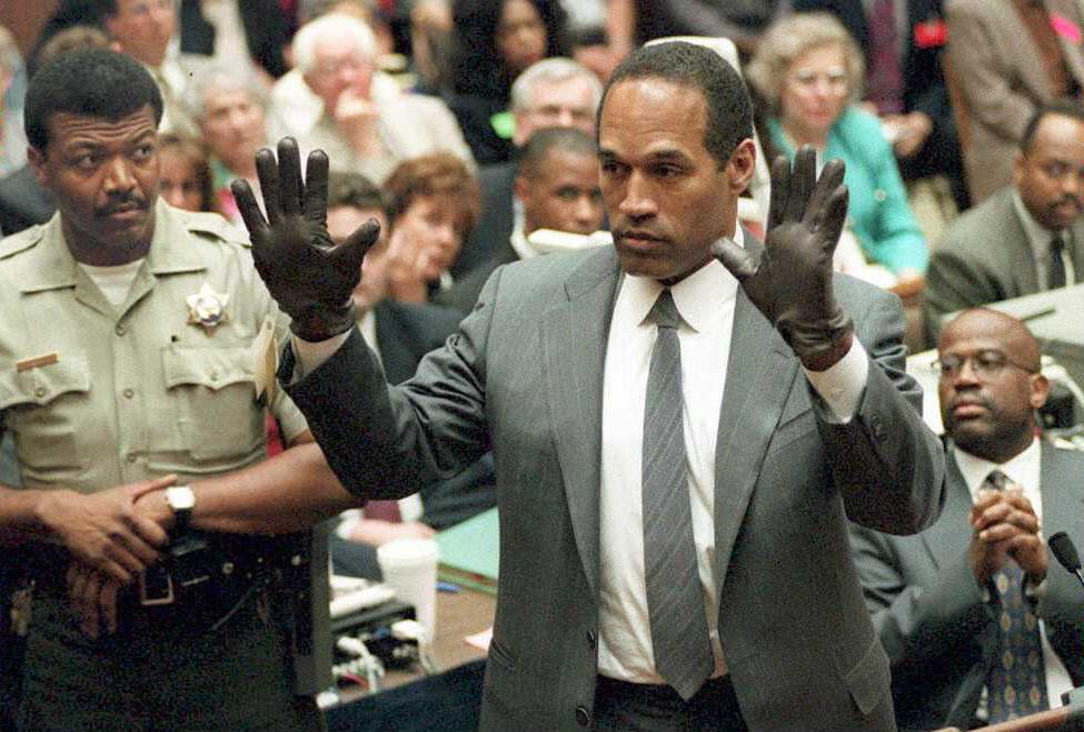 O.J. Simpson holding his hands up, wearing gloves in court
