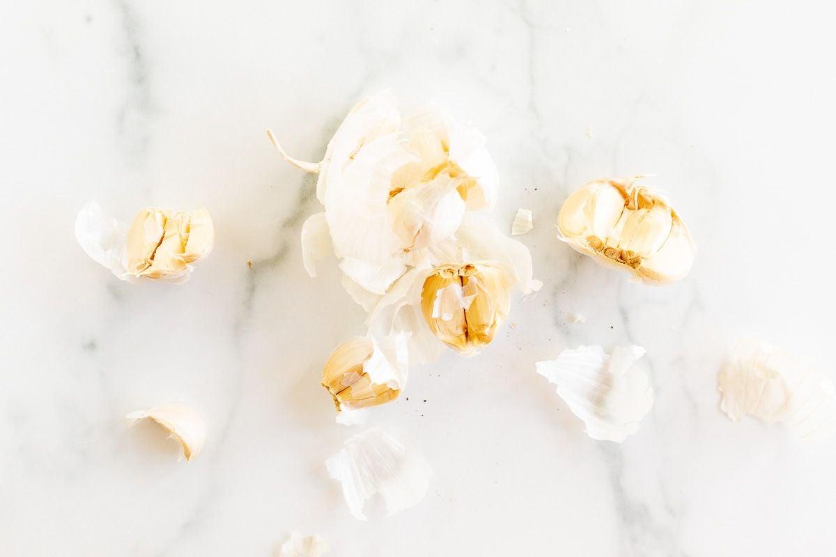 An open head of garlic on a marble countertop.