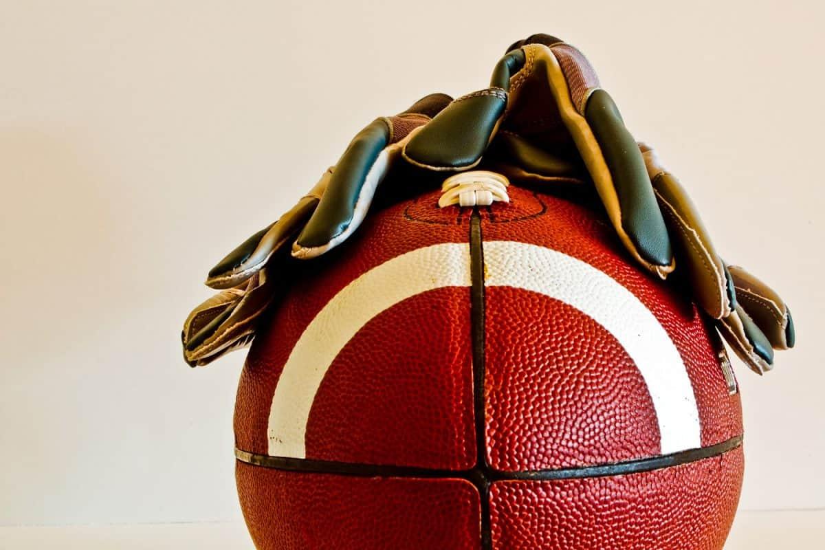 Football gloves placed on top of a football