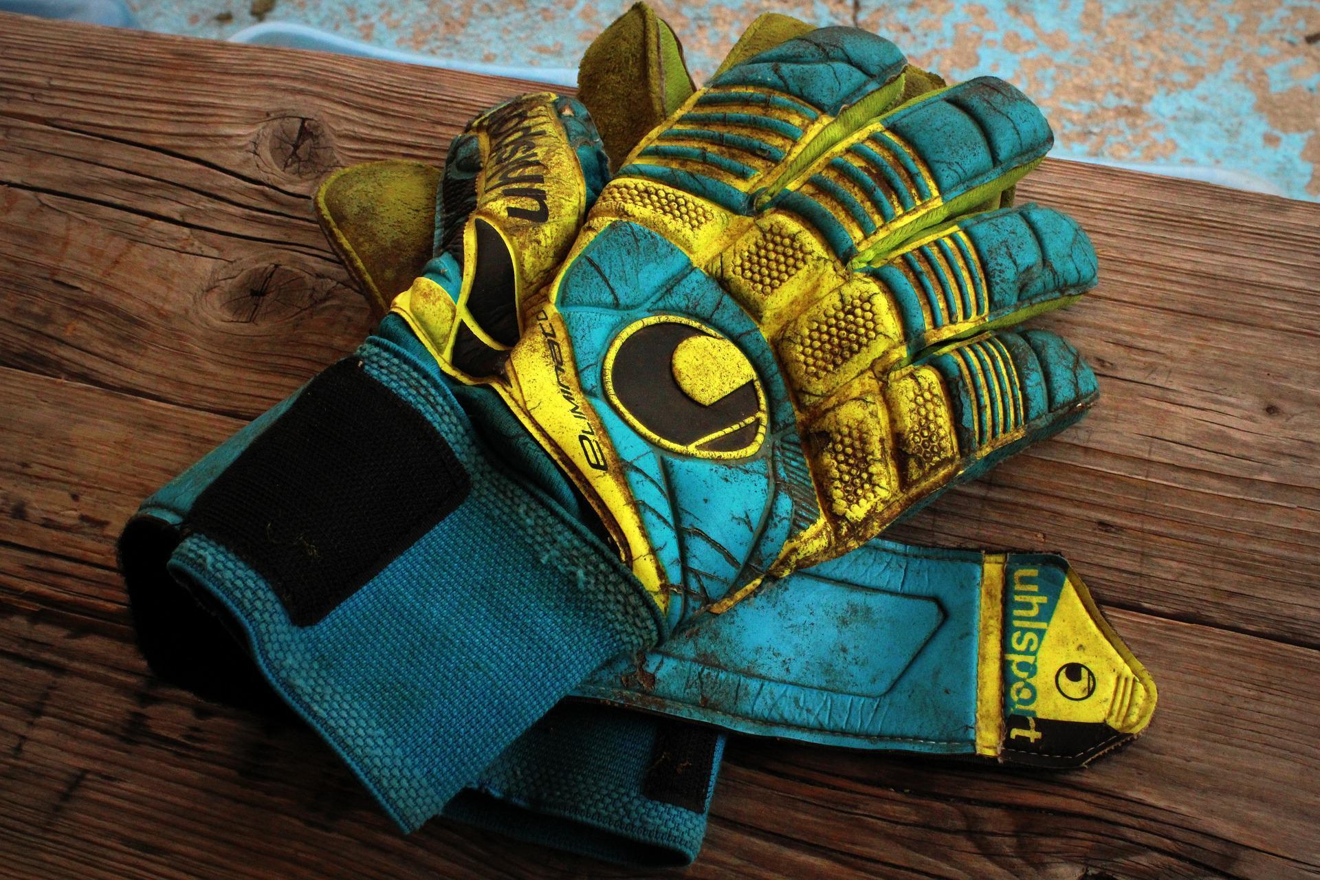 Extremely dirty blue and yellow Uhlsport brand goalkeeper gloves