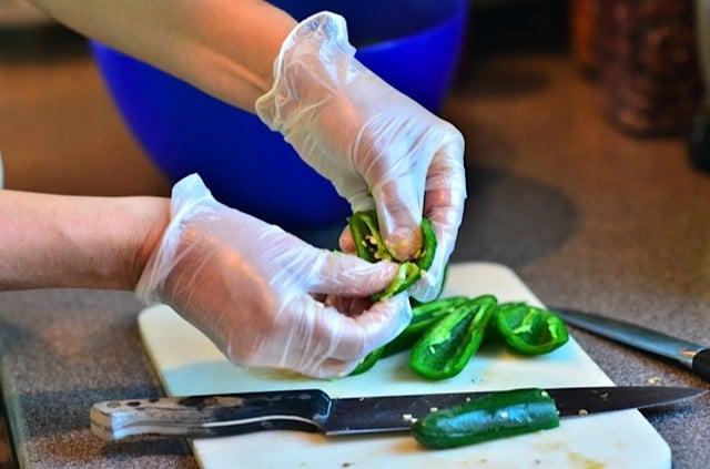wearing gloves and cutting peppers