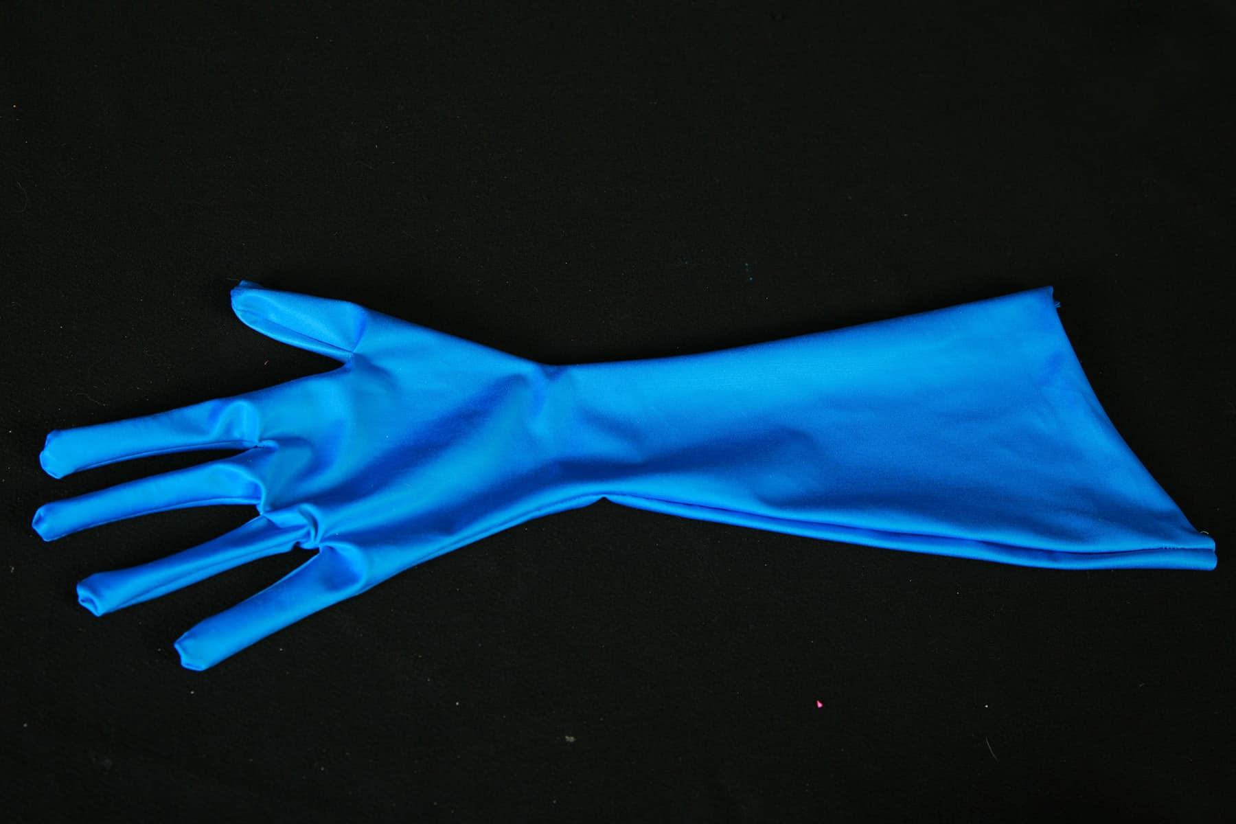 A blue spandex glove against a black background.