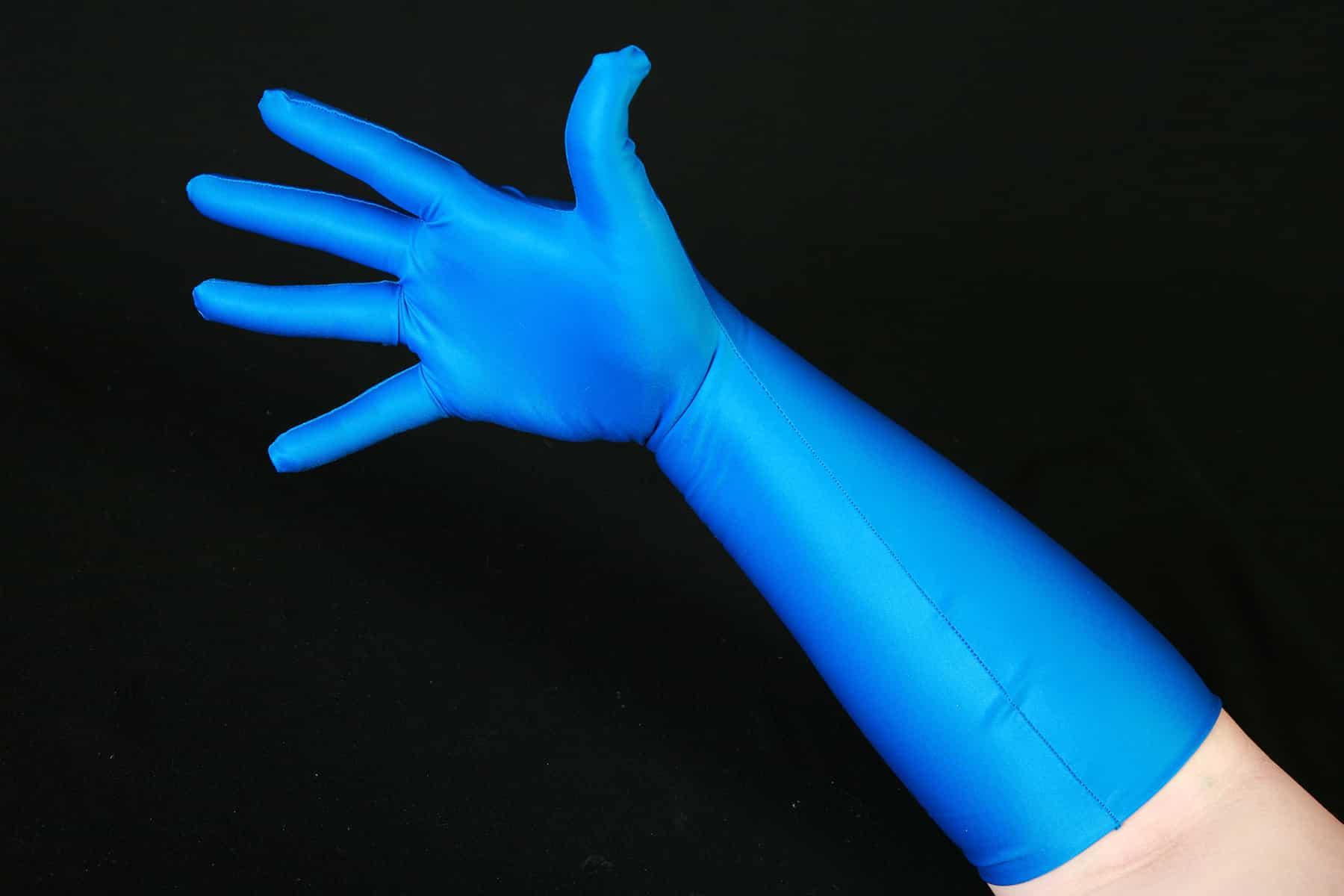 A hand wearing a blue spandex glove against a black background.