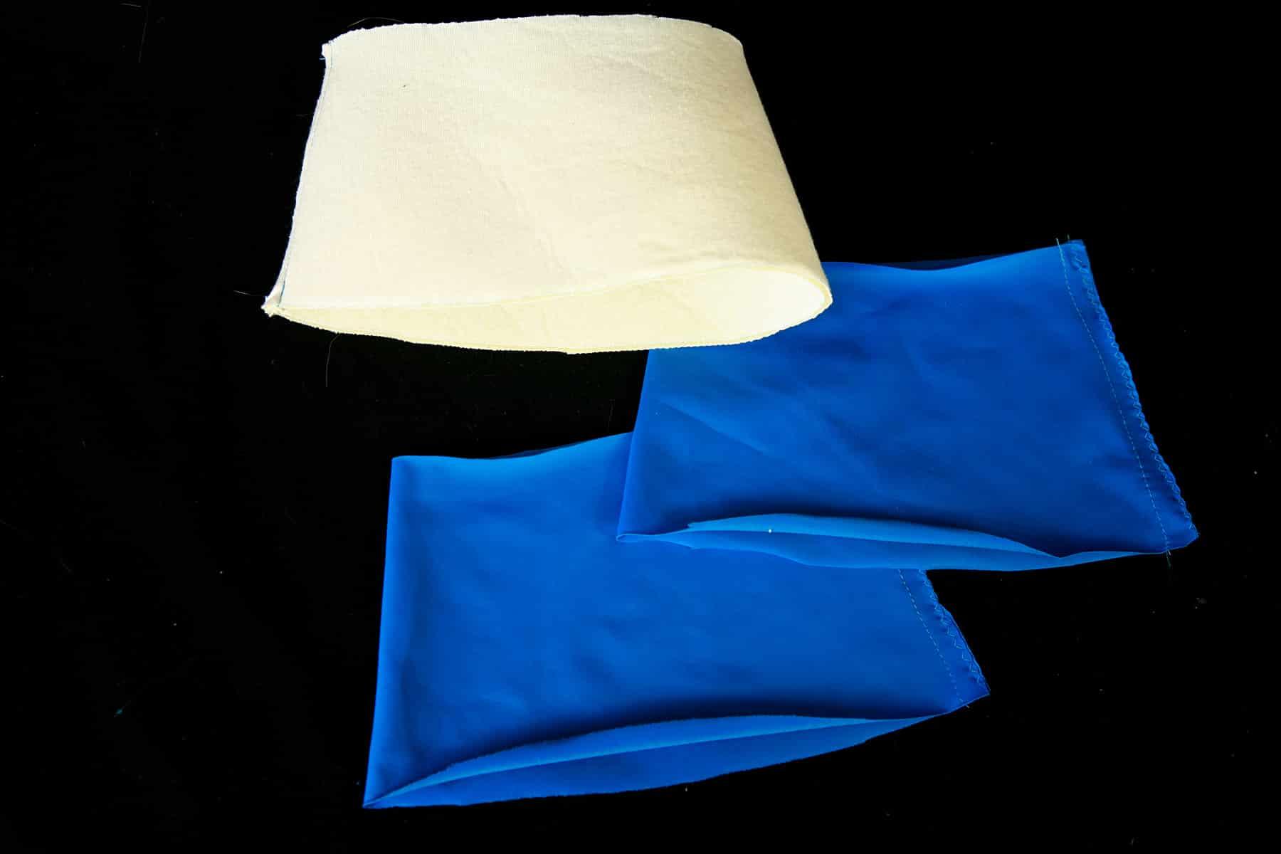 3 cuff pieces - 2 blue spandex pieces, 1 foam piece - laying on a black background.