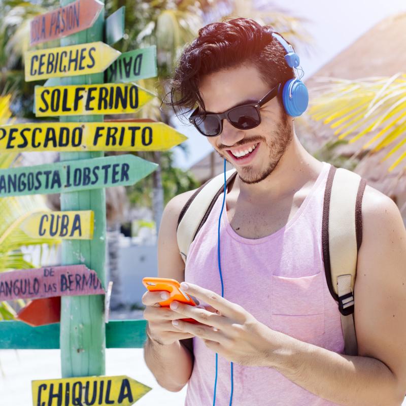 Traveler using their phone while wearing headphones