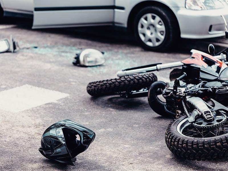 motorcycle laying on the ground next to a helmet