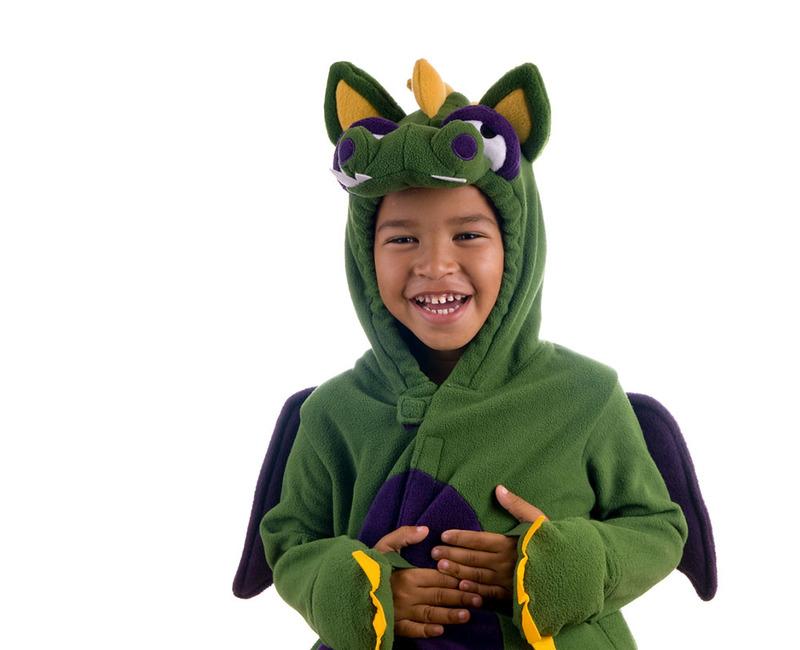 A young child is dressed in a costume that looks sort of like a dragon or monster, he