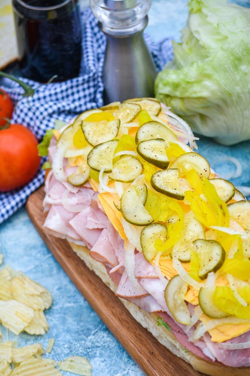 an open face Italian American sub sandwich on a wooden cutting board