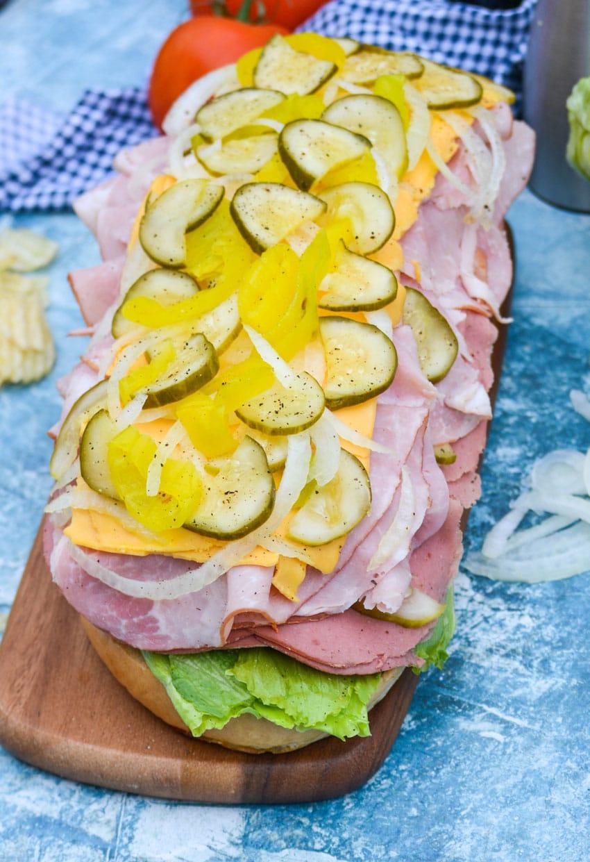 an open face Italian American sub sandwich on a wooden cutting board