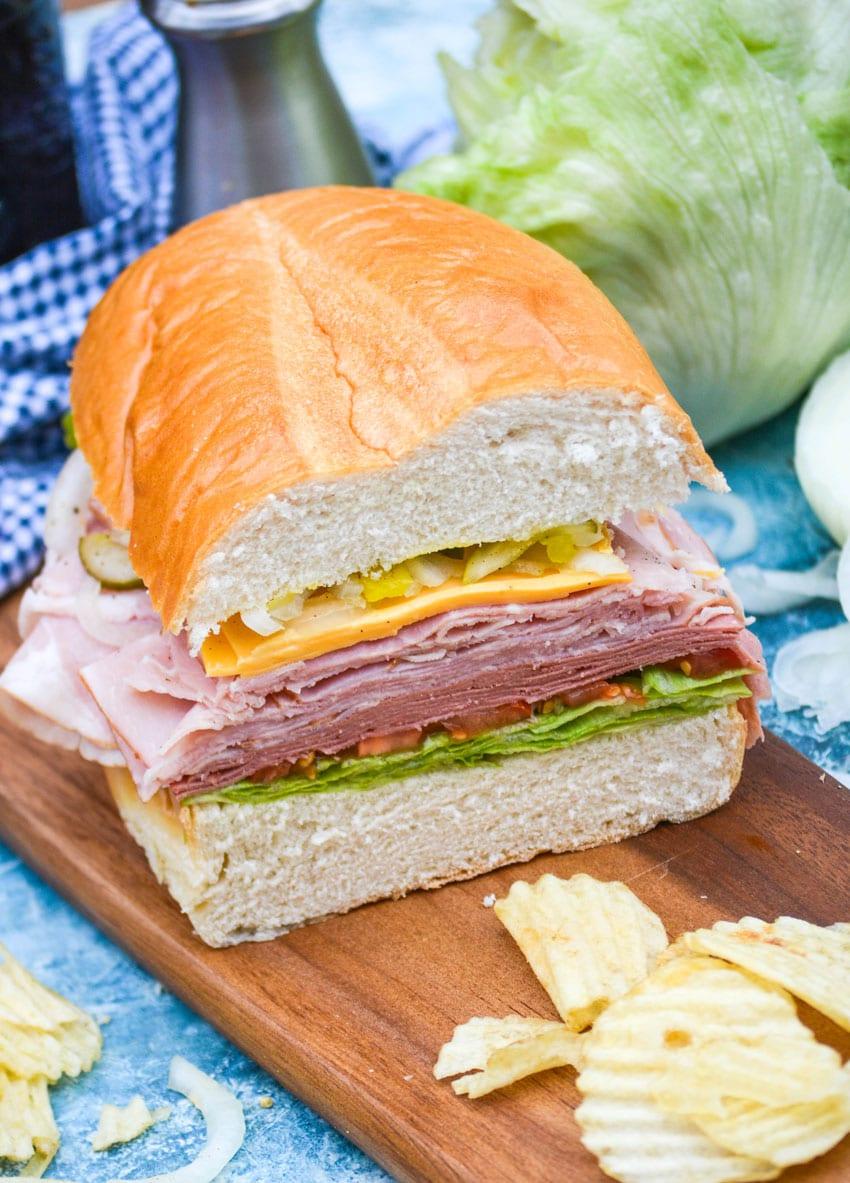 sliced deli style sub sandwiches on a wooden cutting board