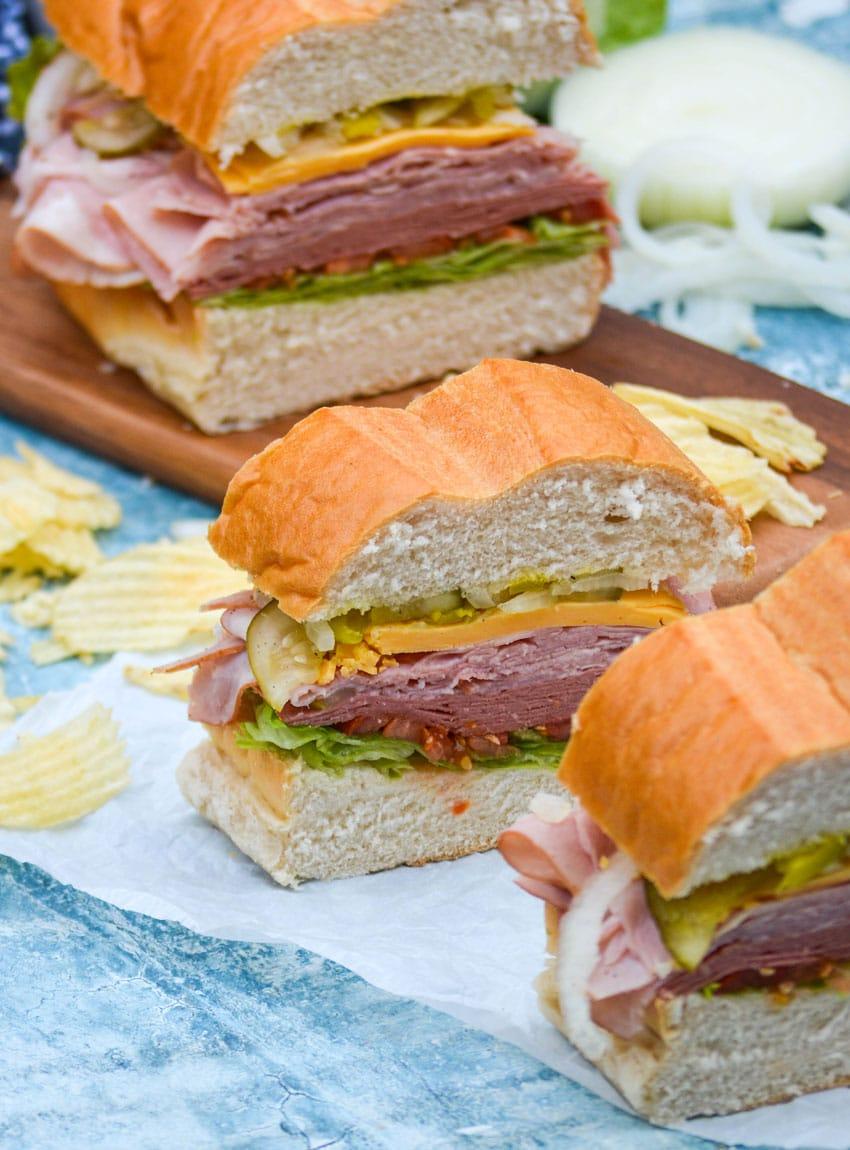 sliced deli style sub sandwiches on white parchment paper