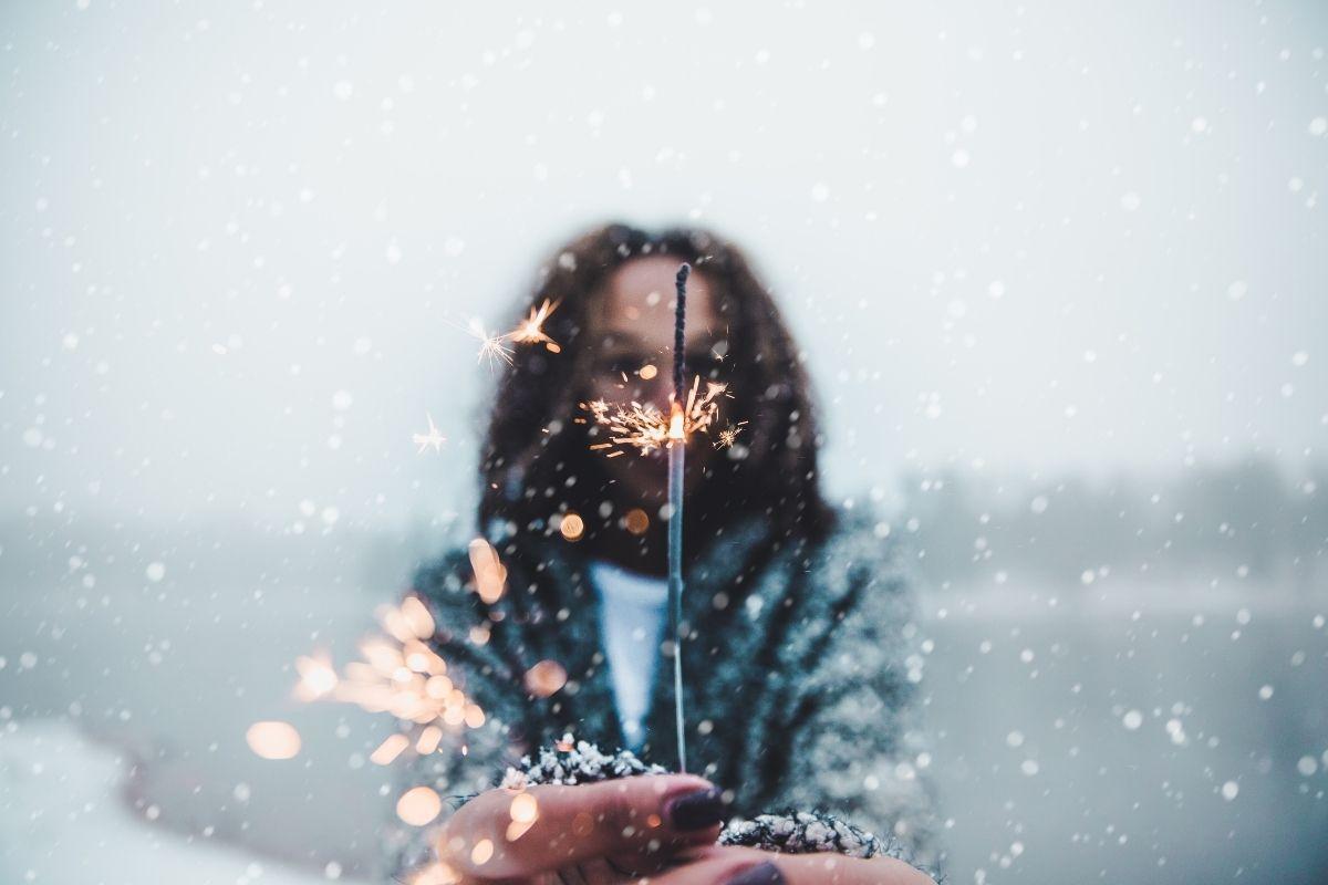 woman with sparkler in snow