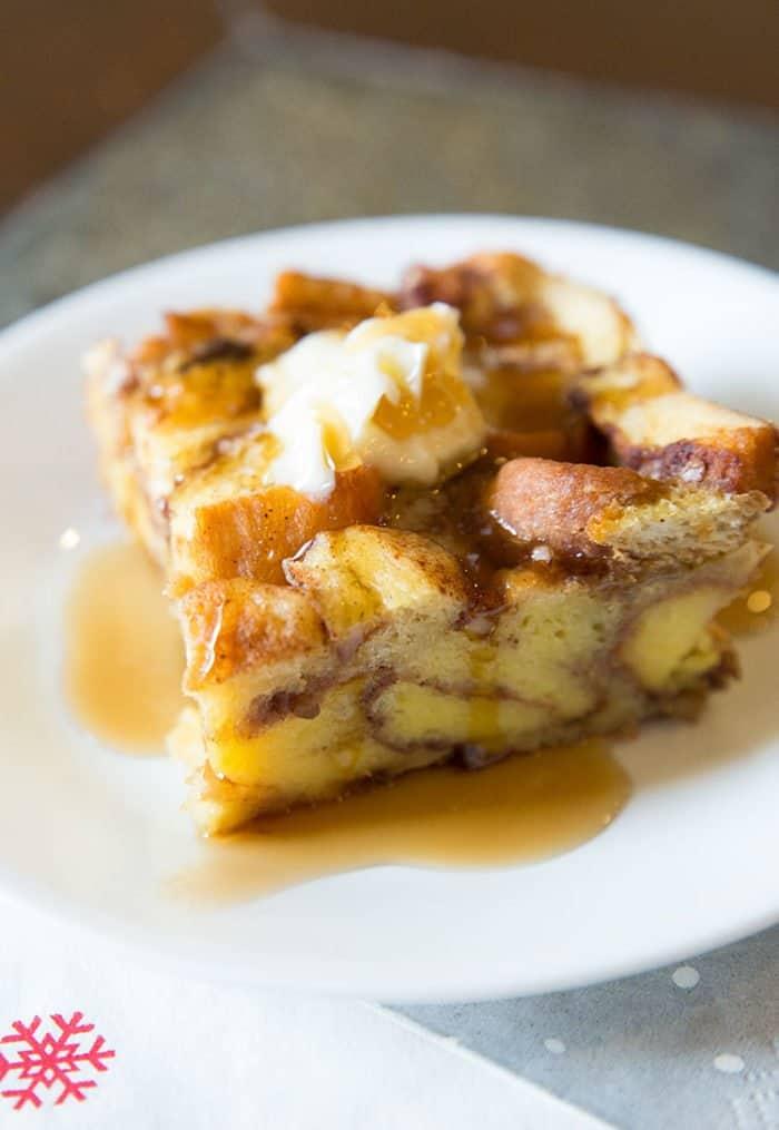 Leftover Cinnamon Rolls French Toast Casserole with Syrup in a White plate