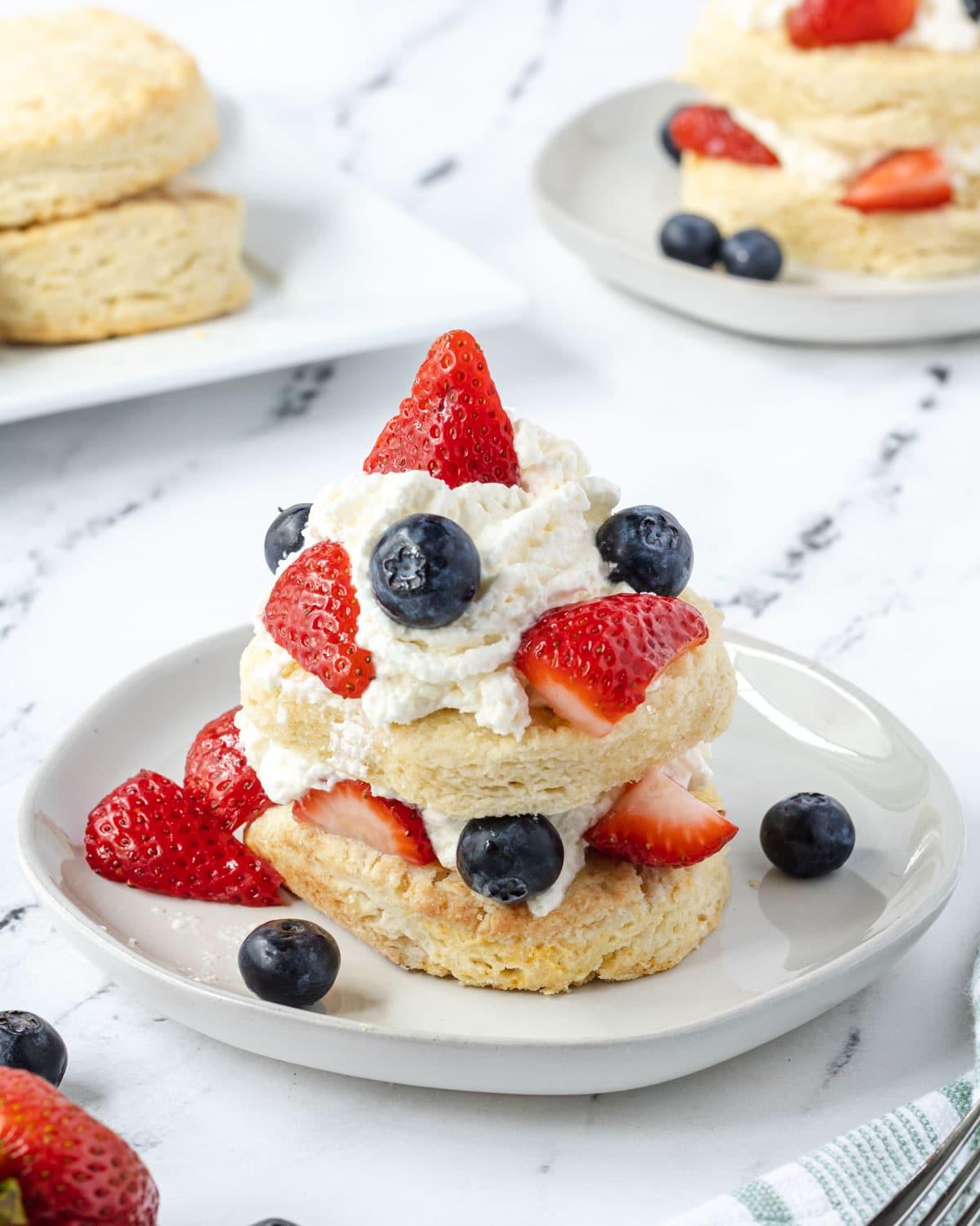 Whipped cream on shortcake with strawberries and blueberries.