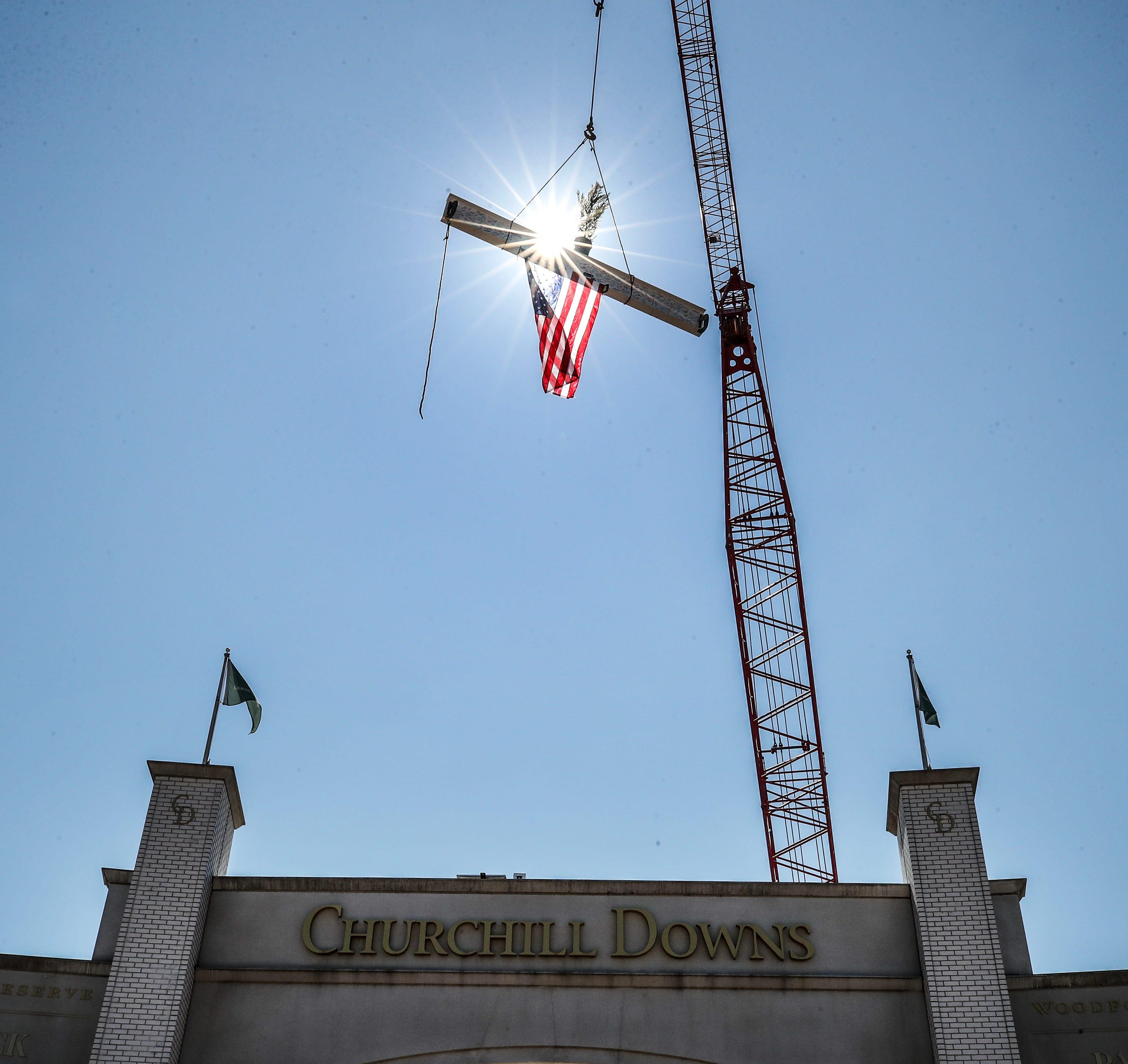 Workers at Churchill Downs lift a beam into place to complete the “Topping Off” ceremony to lower the final piece of steel into place marking a milestone in the completion of a renovated paddock at the track. Wednesday, September 13, 2023