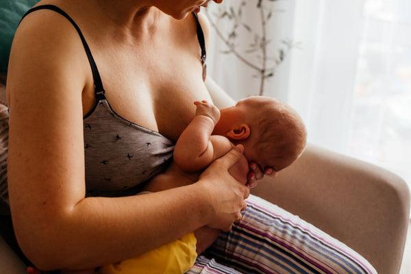 A mother breastfeeding her baby with a skillful latch technique, promoting a comfortable and successful nursing bond.