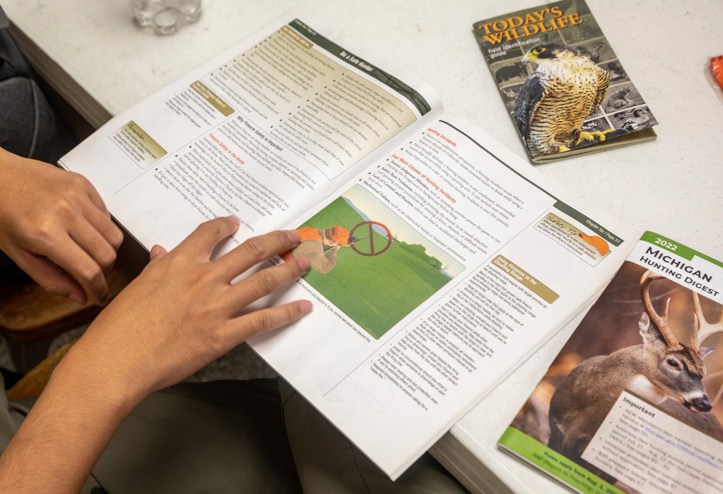 A student looks through a hunting booklet during the Hunter Safety Field Day at the Washtenaw Sportsman