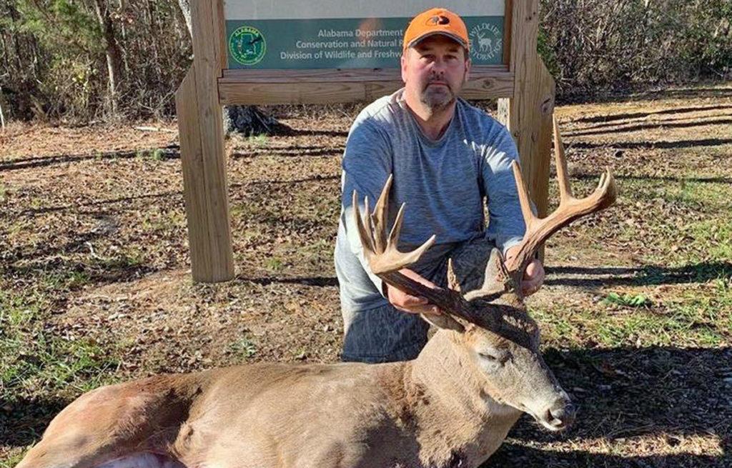 Deer hunter with a large buck taken on an Alabama WMA.