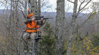 Deer hunters shoot from a stand