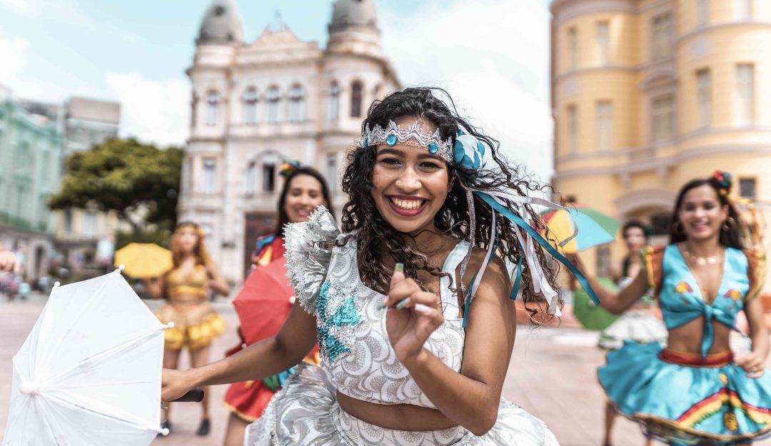 woman-dancing-in-carnaval-in-brazil-wearing-metallic-sparkly-feathers-and-crown