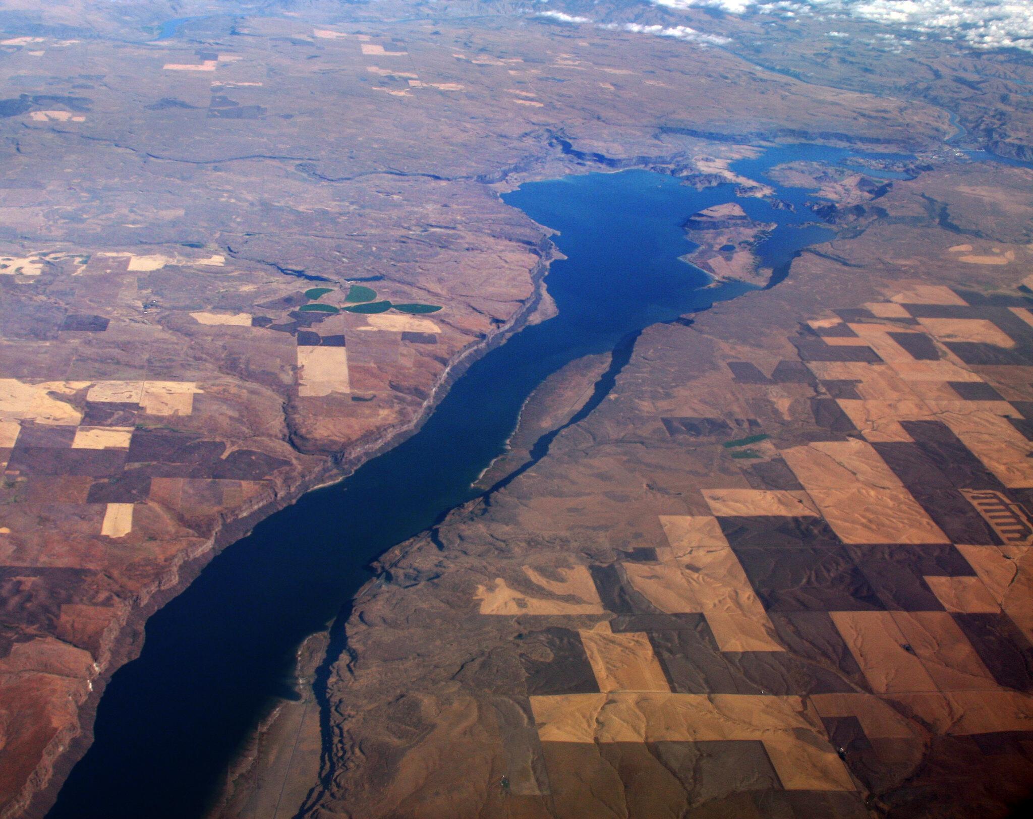 Aerial oblique photo of a partially snow-covered hillside, with ~40 horizontal "contour lines" wrapping around the hillside.